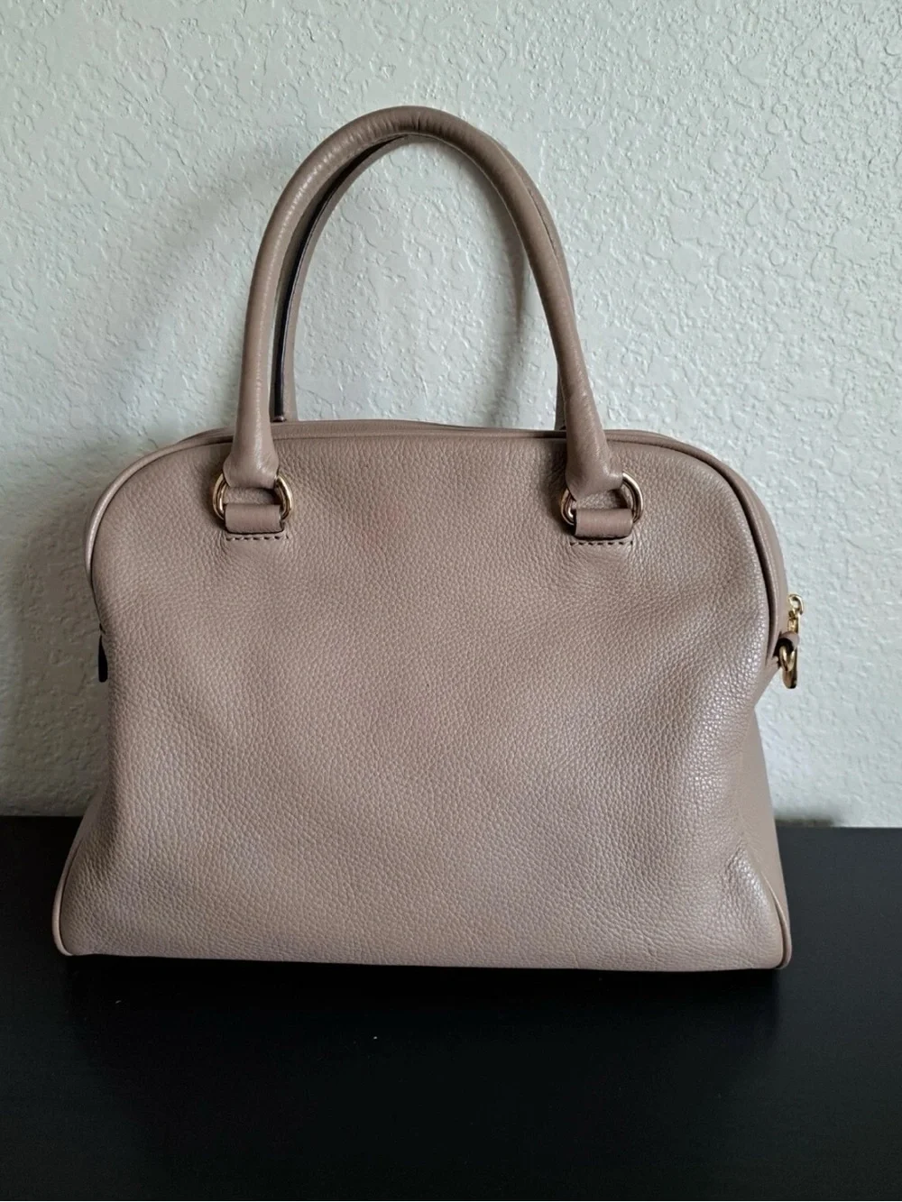 Michael Kors Knox Satchel featuring a prominent tassel and gold-tone hardware